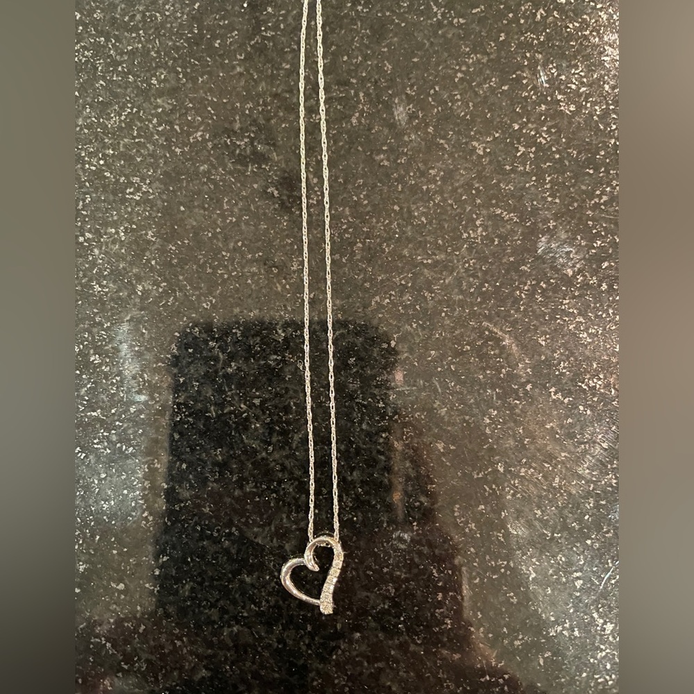 White gold and diamond heart pendant on silver chain.